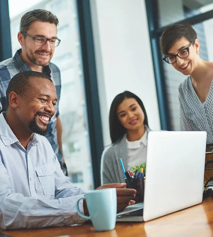 Employees together at a laptop