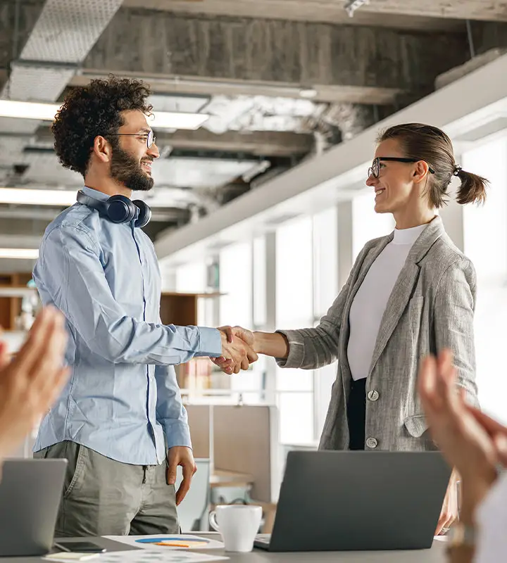 Employee gives another employee a handshake