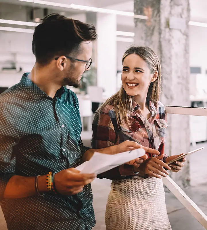 Male employee looks at a female employee, smiling