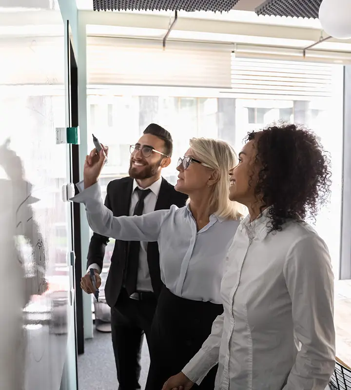 Employees standing in front of the whiteboard