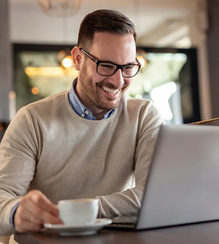 Employee looks at his laptop with a smile